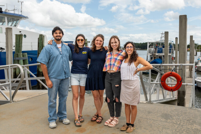 Cohen (right) stands with her research team on the dock in front of the R/V Savannah.