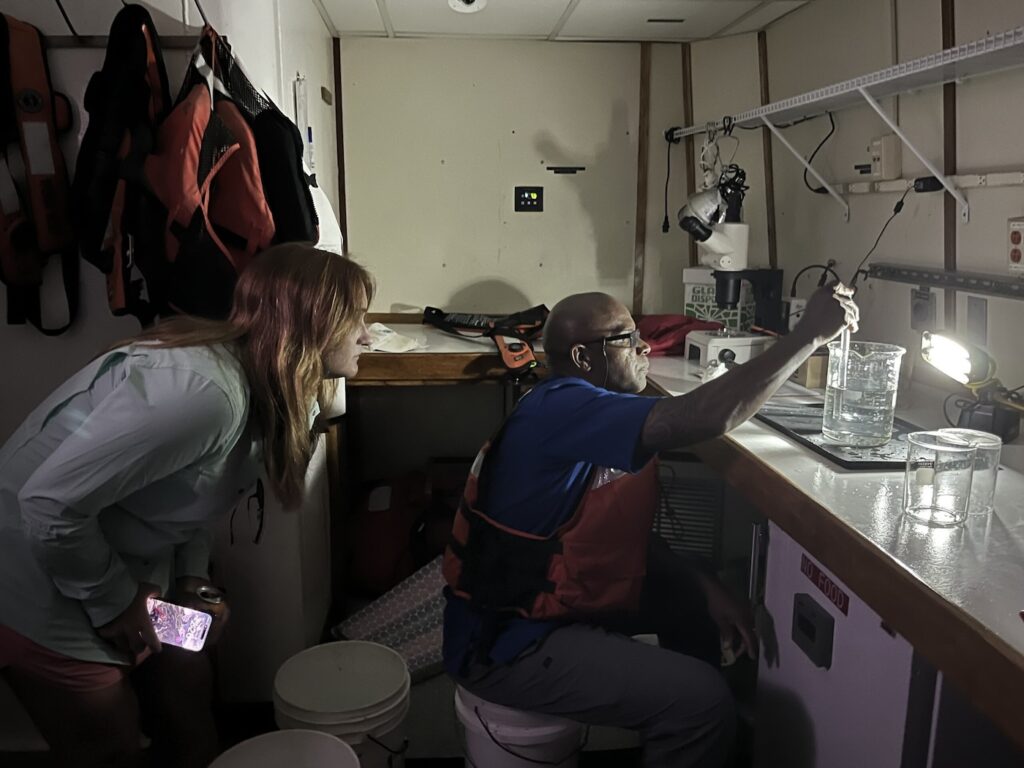 Amanda Fanelli (left) and Principal Muhammad examine plankton on a lab bench inside the R/V Savannah.