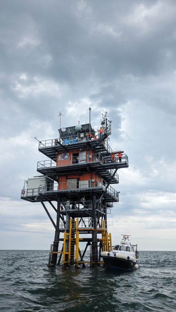 The Acqua Alta Oceanographic Tower. A boat sits beneath it. 