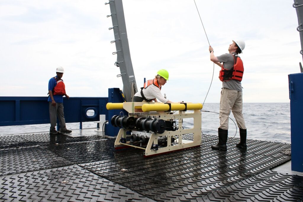 Adam Greer and his lab member Grace Mann hoist the towed plankton imaging system aboard the R/V Savannah. 